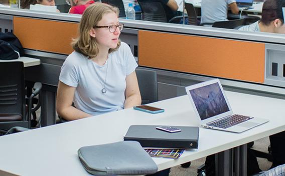 Student conversing at a table in the Woodruff Library common area