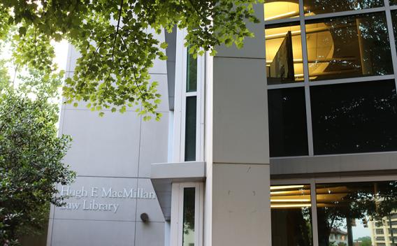 Modern exterior wall and windows of the Hugh F. MacMillan Law Library, framed by trees