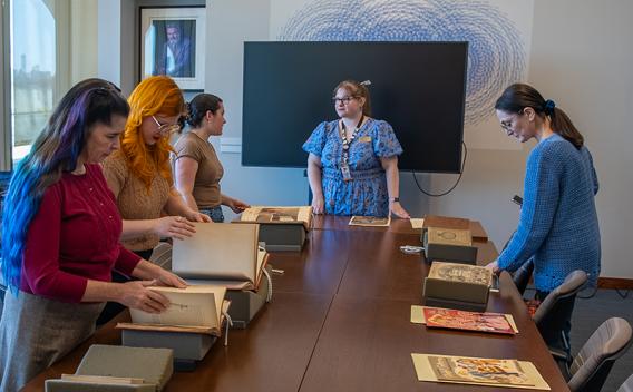 Patrons looking at rare materials at a table in the Rose Library