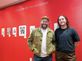Two student artists standing in front of their artworks
