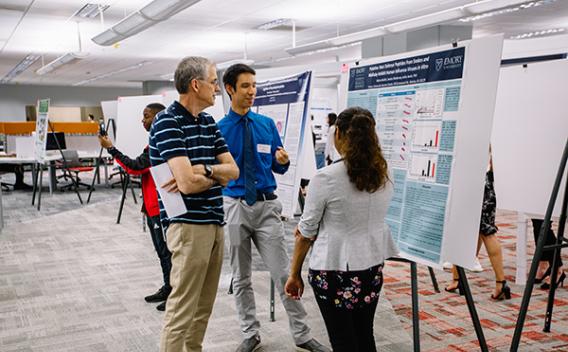 A professor and two student poster presenters